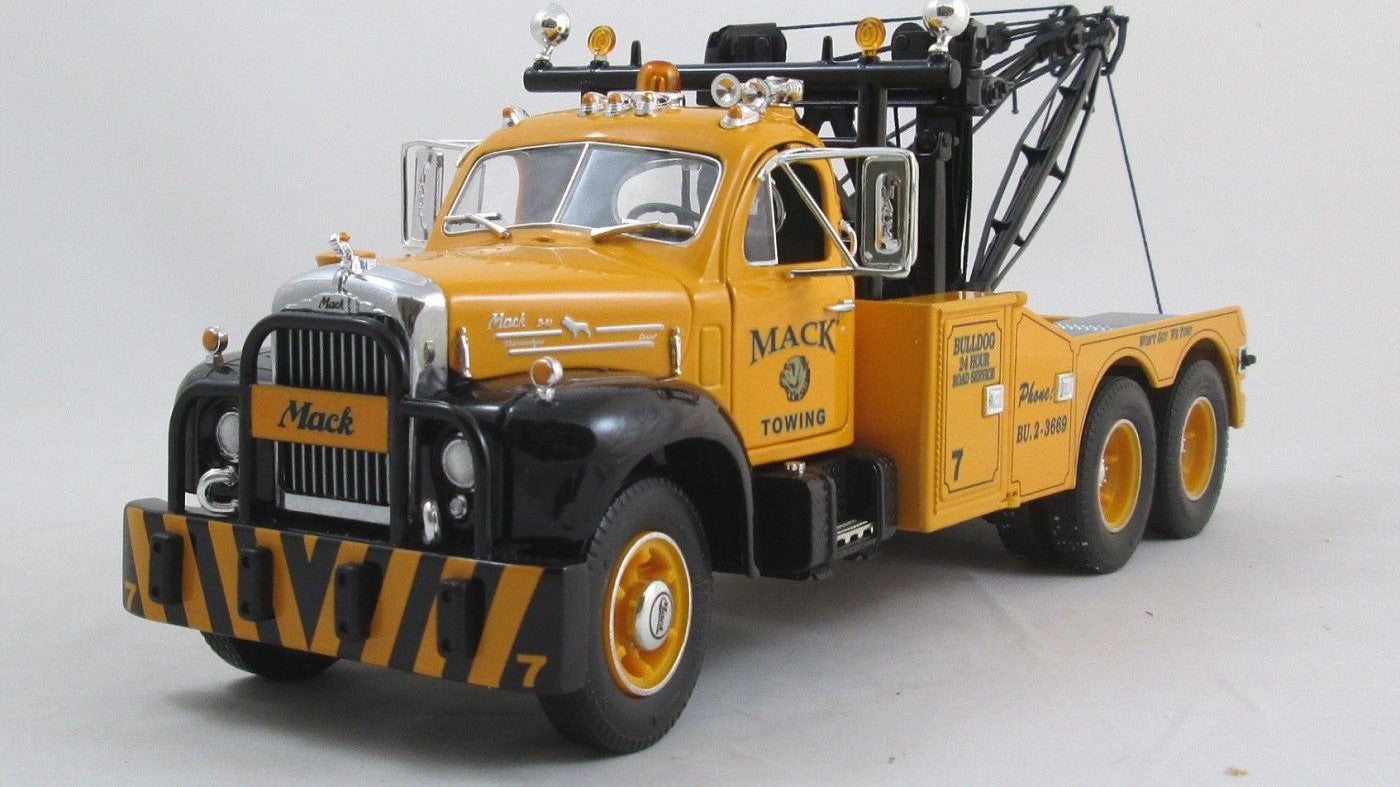 A vintage 1950's black and yellow Mack tow truck diecast scale model