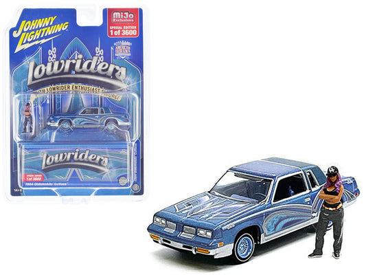 Brand new 1/64 scale diecast car model of 1984 Oldsmobile Cutlass Lowrider Blue Metallic with Graphics and Blue Interior and Diecast Figure 